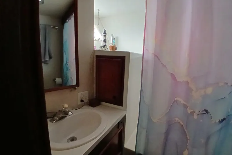 Concrete Idea Yacht Photos Pics Bathroom interior of 1977 Hatteras 48 Long Range Cruiser with sink and colorful shower curtain.