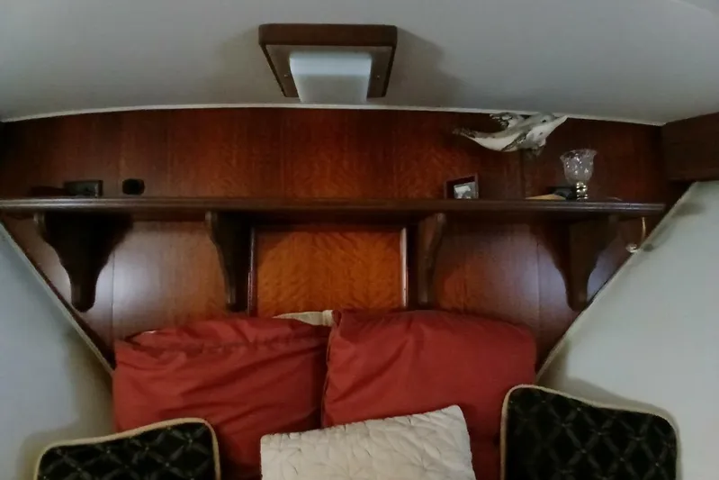 Concrete Idea Yacht Photos Pics Interior of 1977 Hatteras 48 Long Range Cruiser with wooden shelves and red cushions.