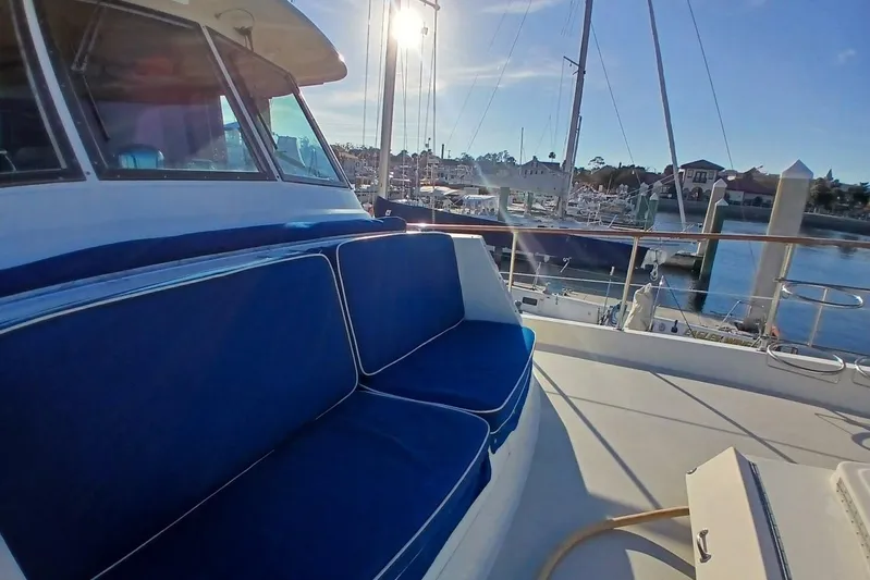Concrete Idea Yacht Photos Pics 1977 Hatteras 48 Long Range Cruiser with blue seating, docked at a marina.