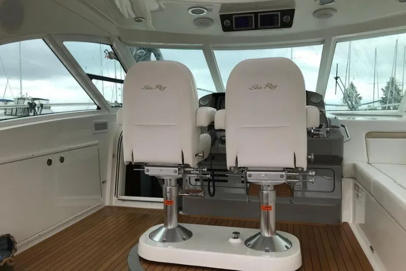 Ocean Blue III Yacht Photos Pics 2010 Sea Ray Sundancer 540 cockpit with dual white captain chairs and wooden flooring.