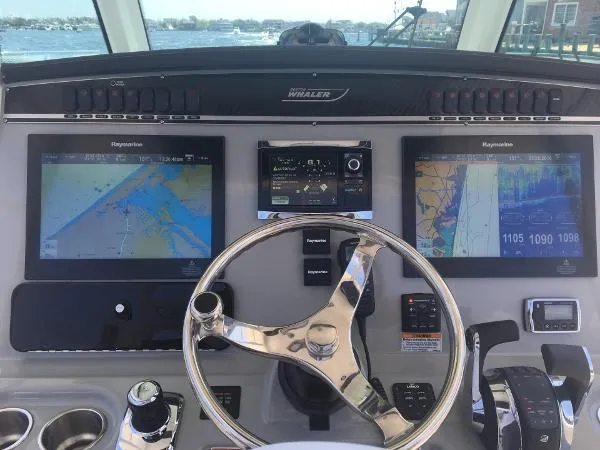  Yacht Photos Pics Control panel of a 2016 Boston Whaler 350 Outrage with navigation screens and steering wheel.