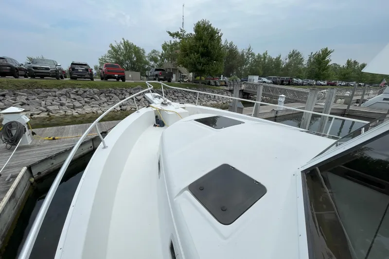  Yacht Photos Pics 2000 Mainship 390 Trawler docked at marina, surrounded by parked cars and trees.
