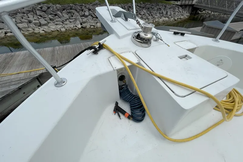  Yacht Photos Pics Mainship 390 Trawler 2000 deck with winch, hoses, and dock view.