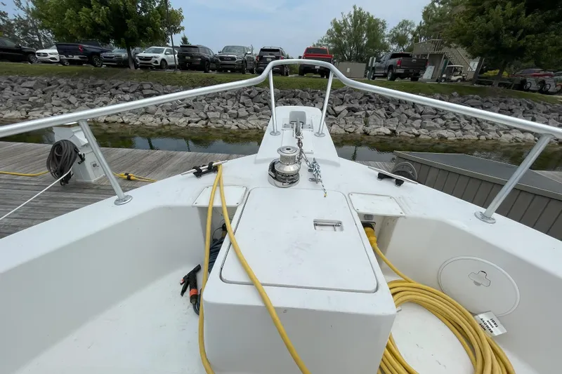  Yacht Photos Pics Bow view of 2000 Mainship 390 Trawler docked, featuring deck equipment and shoreline.