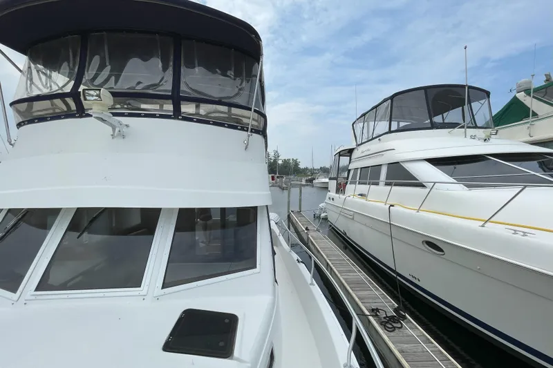  Yacht Photos Pics 2000 Mainship 390 Trawler docked alongside another boat on a sunny day.