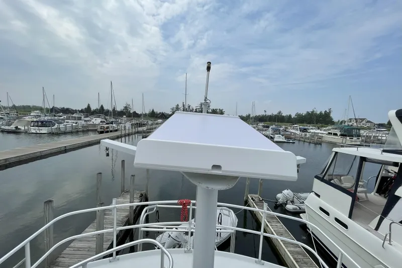  Yacht Photos Pics 2000 Mainship 390 Trawler docked at marina, surrounded by boats under cloudy sky.