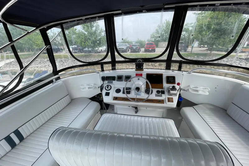  Yacht Photos Pics 2000 Mainship 390 Trawler helm with steering wheel, controls, and seating.