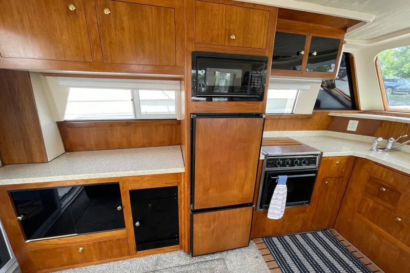  Yacht Photos Pics Kitchen area of 2000 Mainship 390 Trawler with wood cabinetry and modern appliances.