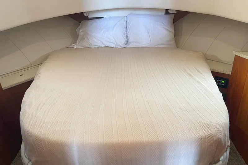  Yacht Photos Pics Cozy cabin bed in 2000 Mainship 390 Trawler with white bedding and wood accents.