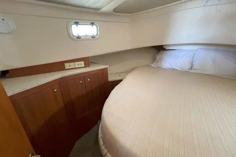  Yacht Photos Pics Cozy cabin interior of 2000 Mainship 390 Trawler with bed and wooden cabinetry.
