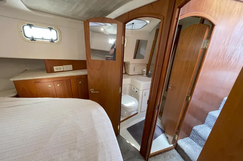  Yacht Photos Pics Interior of 2000 Mainship 390 Trawler with wood cabinetry, bed, and compact bathroom.