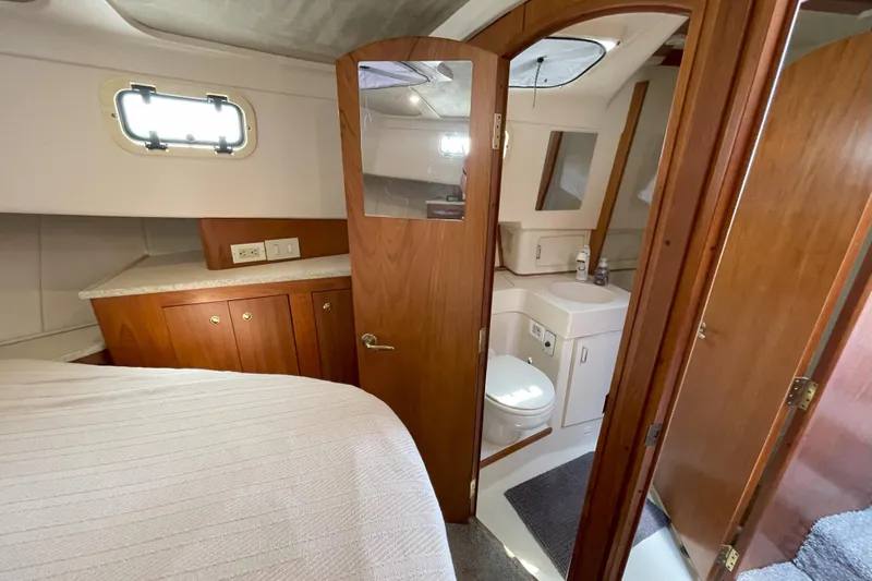  Yacht Photos Pics 2000 Mainship 390 Trawler interior with wood cabinetry, bed, and compact bathroom.