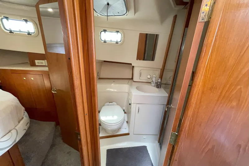 Yacht Photos Pics Bathroom interior of 2000 Mainship 390 Trawler with wooden cabinetry and compact design.