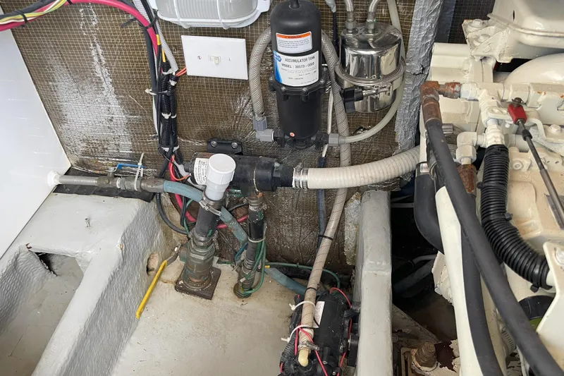  Yacht Photos Pics Engine room of 2000 Mainship 390 Trawler with visible plumbing and wiring components.