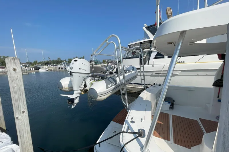  Yacht Photos Pics 2000 Mainship 390 Trawler docked with outboard motor and dinghy, sunny marina setting.