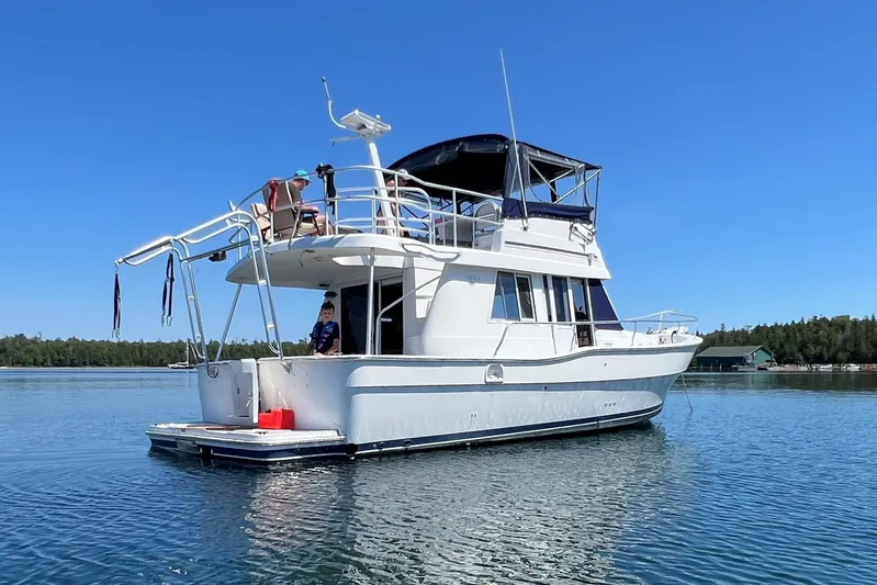  Yacht Photos Pics 2000 Mainship 390 Trawler on calm water under clear blue sky.