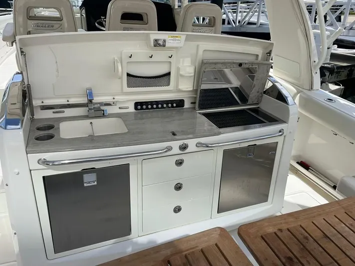 Bite Me Yacht Photos Pics 2017 Boston Whaler 420 Outrage boat kitchen with sink, grill, and storage.