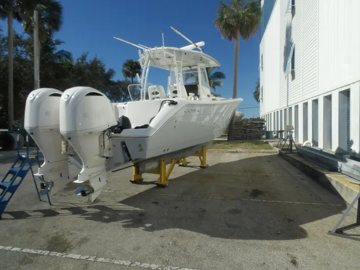  Yacht Photos Pics 2020 Cobia 320 Center Console boat with dual engines on a dockside platform.