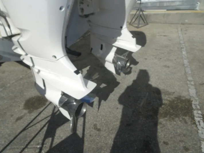  Yacht Photos Pics Twin outboard motors on a 2020 Cobia 320 Center Console boat, parked on concrete.