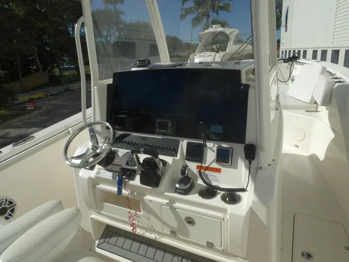  Yacht Photos Pics 2020 Cobia 320 Center Console boat dashboard with steering wheel and navigation controls.