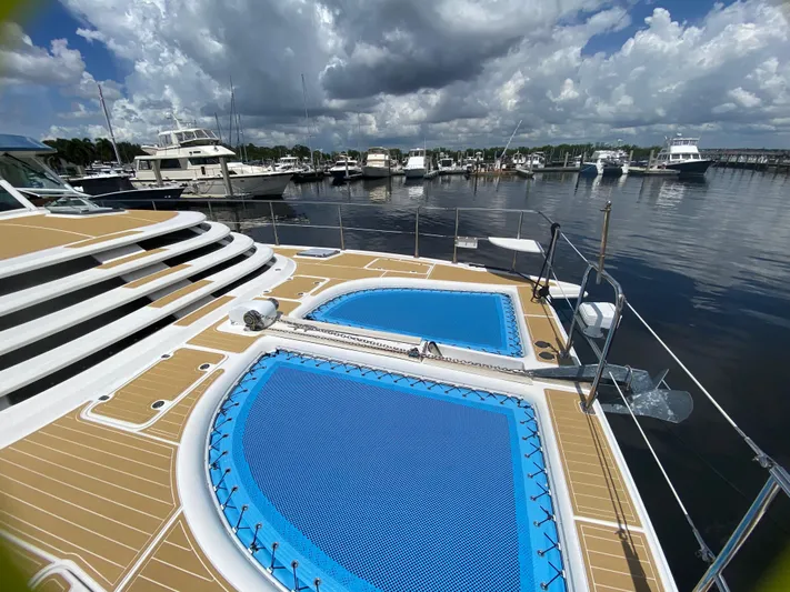 Lah De Dah Yacht Photos Pics 2007 Manta 44 Power Cat with netted deck, docked at marina under cloudy sky.
