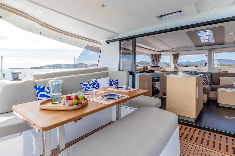  Yacht Photos Pics Manufacturer Provided Image: Luxurious interior of 2026 Fountaine Pajot FP44 Catamaran with dining area and scenic ocean view.