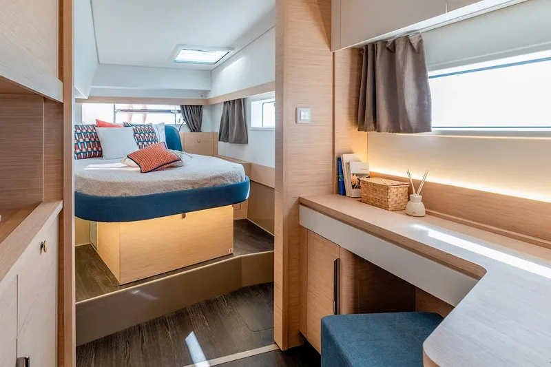 Yacht Photos Pics Manufacturer Provided Image: Luxurious interior of 2026 Fountaine Pajot FP44 Catamaran with modern bedroom and workspace.