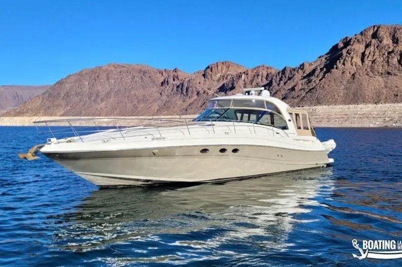  Yacht Photos Pics 2005 Sea Ray 500 Sundancer yacht on a serene lake with rocky mountains.