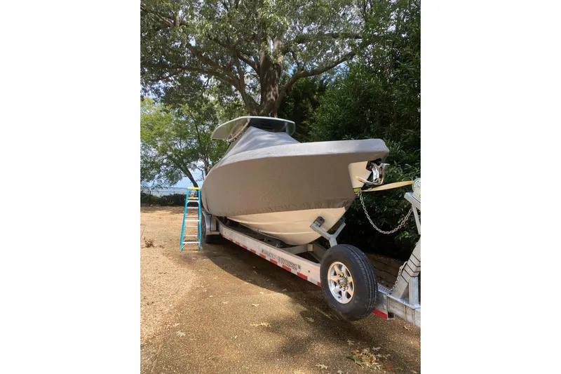  Yacht Photos Pics 2023 Statement 350 Open boat covered on trailer, parked outdoors under trees.