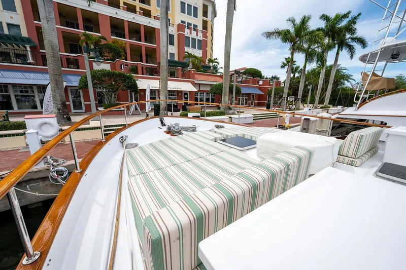 Motivated Seller Yacht Photos Pics 1986 Tollycraft Pilothouse yacht docked near waterfront buildings and palm trees.