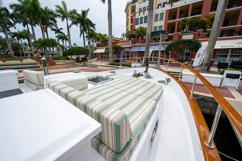 Motivated Seller Yacht Photos Pics 1986 Tollycraft Pilothouse boat with striped seating docked near palm trees and buildings.