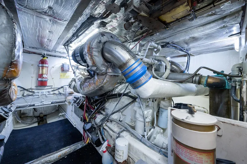 Motivated Seller Yacht Photos Pics Engine room of a 1986 Tollycraft Pilothouse yacht with visible machinery and fire extinguisher.