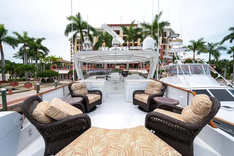 Motivated Seller Yacht Photos Pics 1986 Tollycraft Pilothouse yacht with outdoor seating, docked at a marina with palm trees.