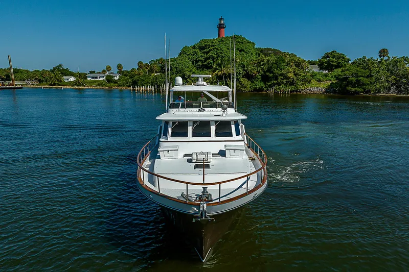Motivated Seller Yacht Photos Pics 1986 Tollycraft Pilothouse yacht cruising on a serene river with lush greenery.