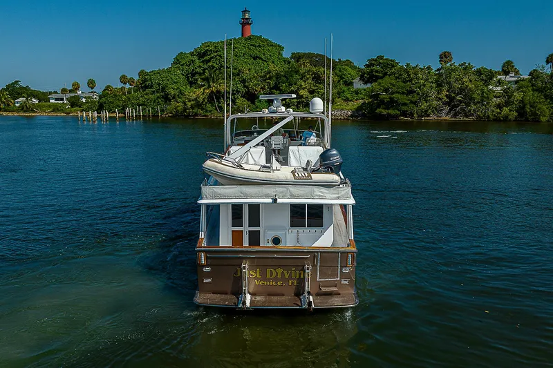 Motivated Seller Yacht Photos Pics 1986 Tollycraft Pilothouse boat cruising on a scenic waterway with lush greenery.