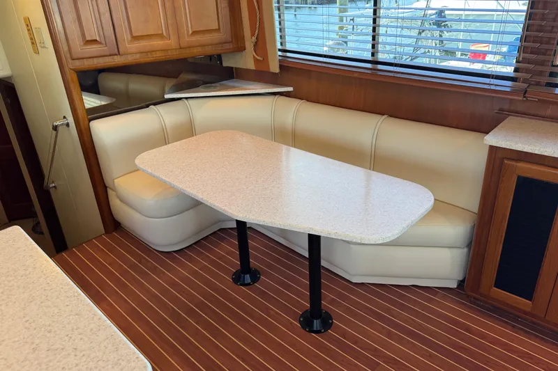  Yacht Photos Pics Interior of 1995 Viking 58 Convertible yacht with dining area and wooden flooring.