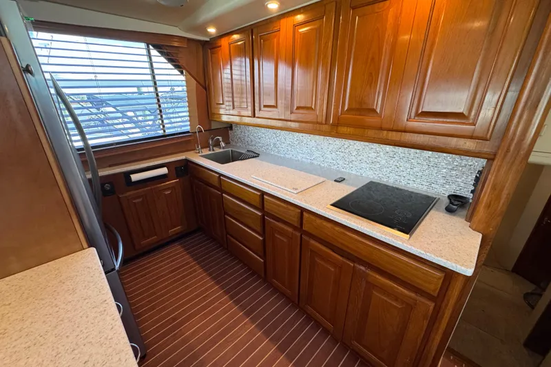  Yacht Photos Pics Luxurious kitchen interior of 1995 Viking 58 Convertible yacht with wooden cabinetry.