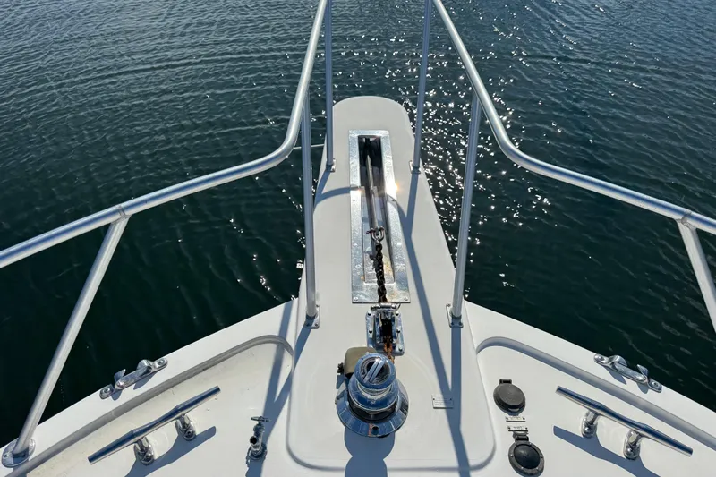  Yacht Photos Pics Bow of 1995 Viking 58 Convertible yacht with anchor chain over water.