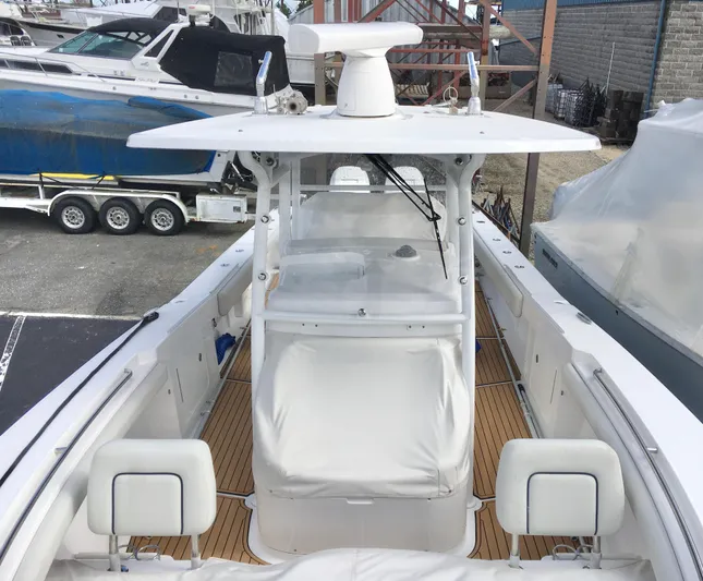  Yacht Photos Pics 2020 Southport 33 FE boat with white console and teak deck, docked near other boats.