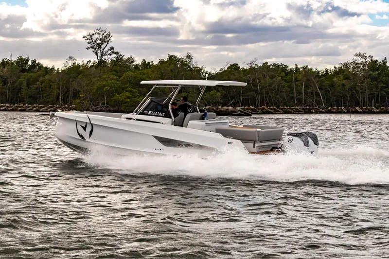  Yacht Photos Pics Electric STERK 31 boat cruising on water, 2025 model, with lush greenery in background.