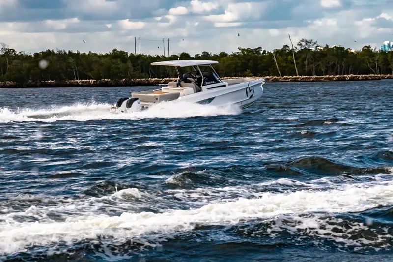  Yacht Photos Pics 2025 STERK 31 boat cruising on a scenic waterway under a cloudy sky.