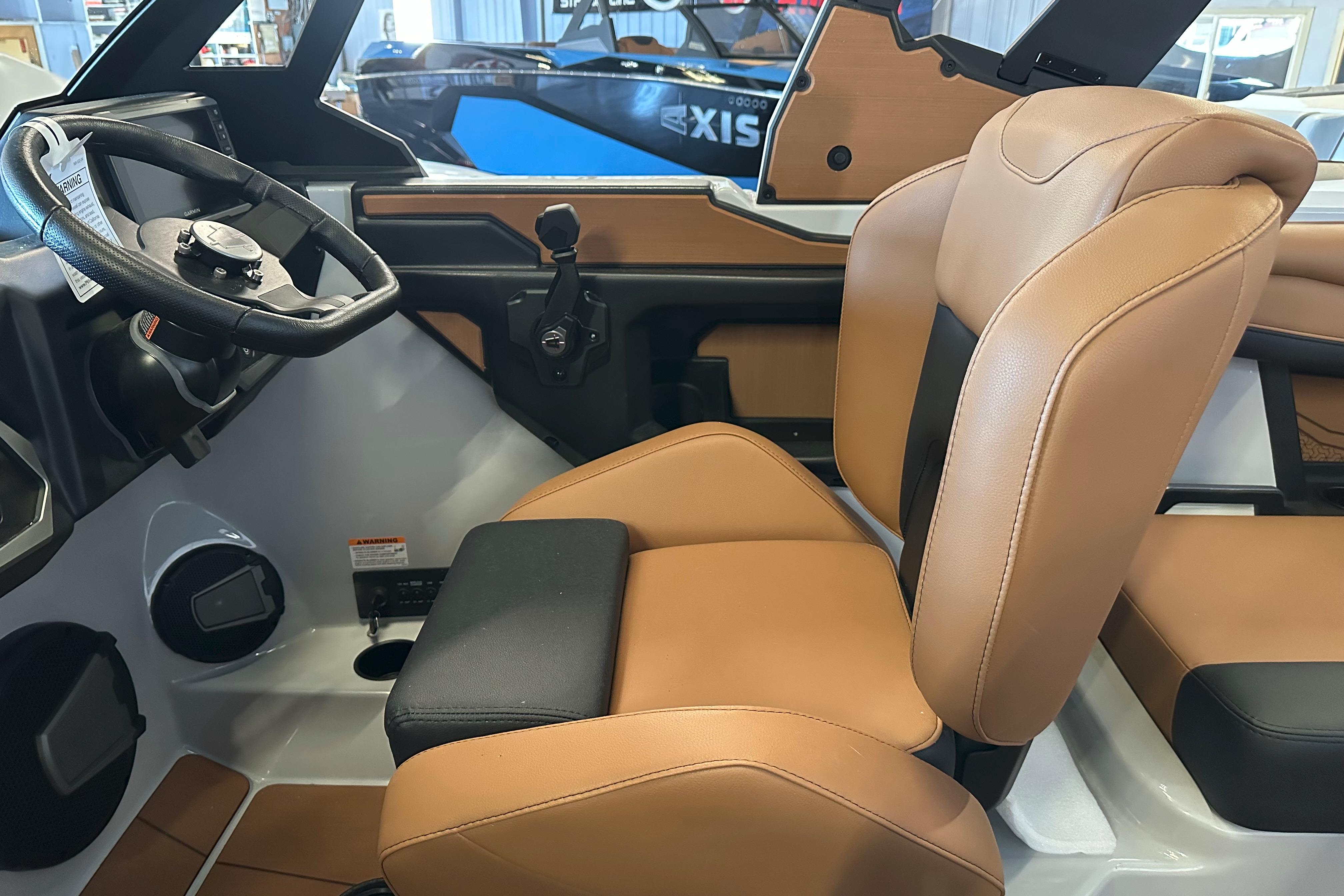 Interior of 2026 Axis A225 boat with tan leather seats and steering wheel.