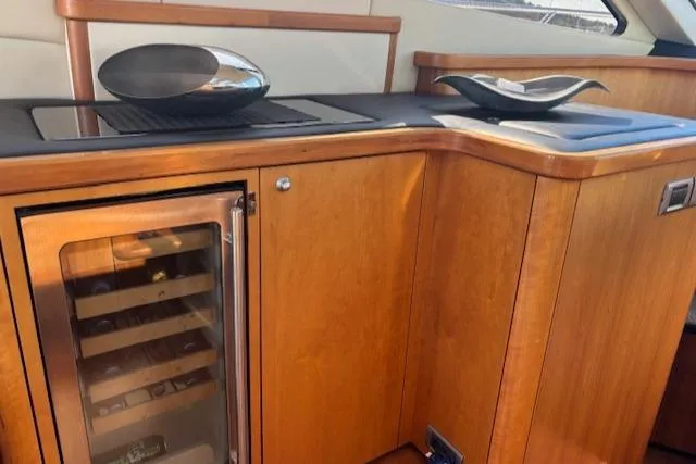 Joško Marić Yacht Photos Pics Luxurious wooden interior of 2008 Sunseeker Predator 72 yacht with wine cooler and modern decor.