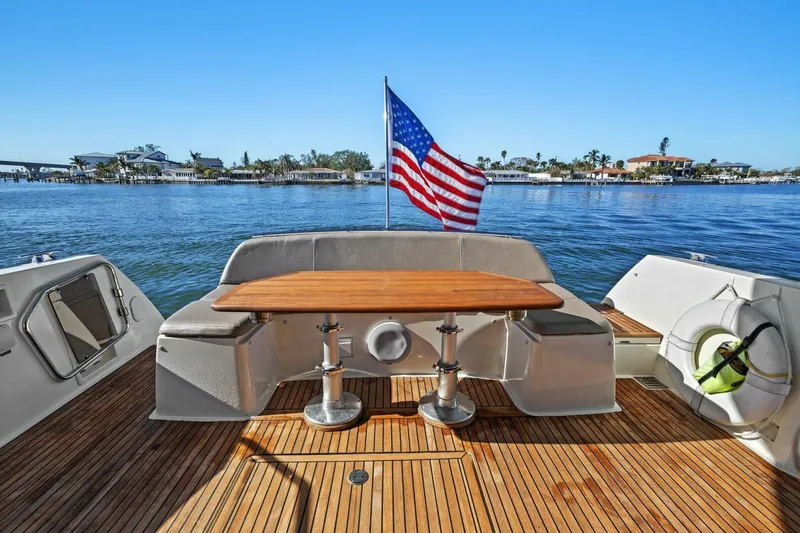 Slainte Yacht Photos Pics Prestige 450 S yacht, 2014 model, with American flag, docked on serene waters.
