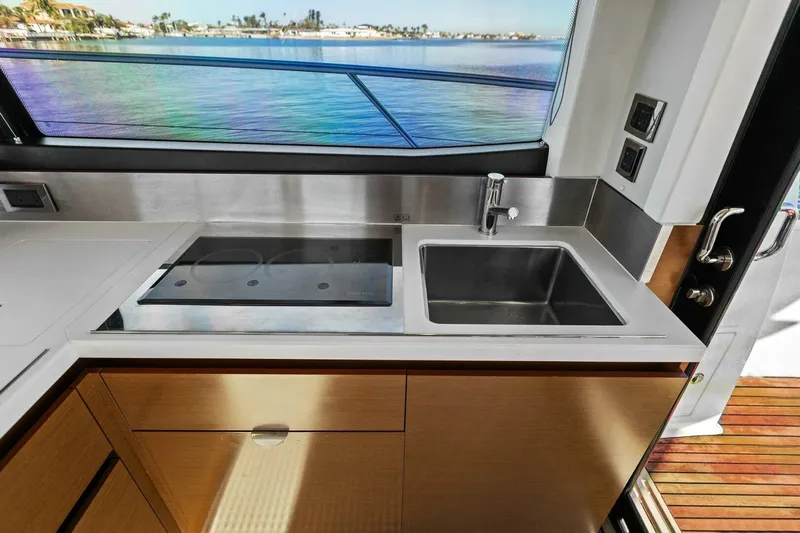 Slainte Yacht Photos Pics Prestige 450 S 2014 yacht kitchen with sink and stove, overlooking scenic water view.
