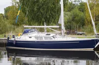 Sailboat CR 400 DS 2002 docked by lush greenery and calm water.