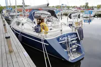 Sailboat docked at marina, CR 400 DS, 2002 model, with blue hull and white deck.