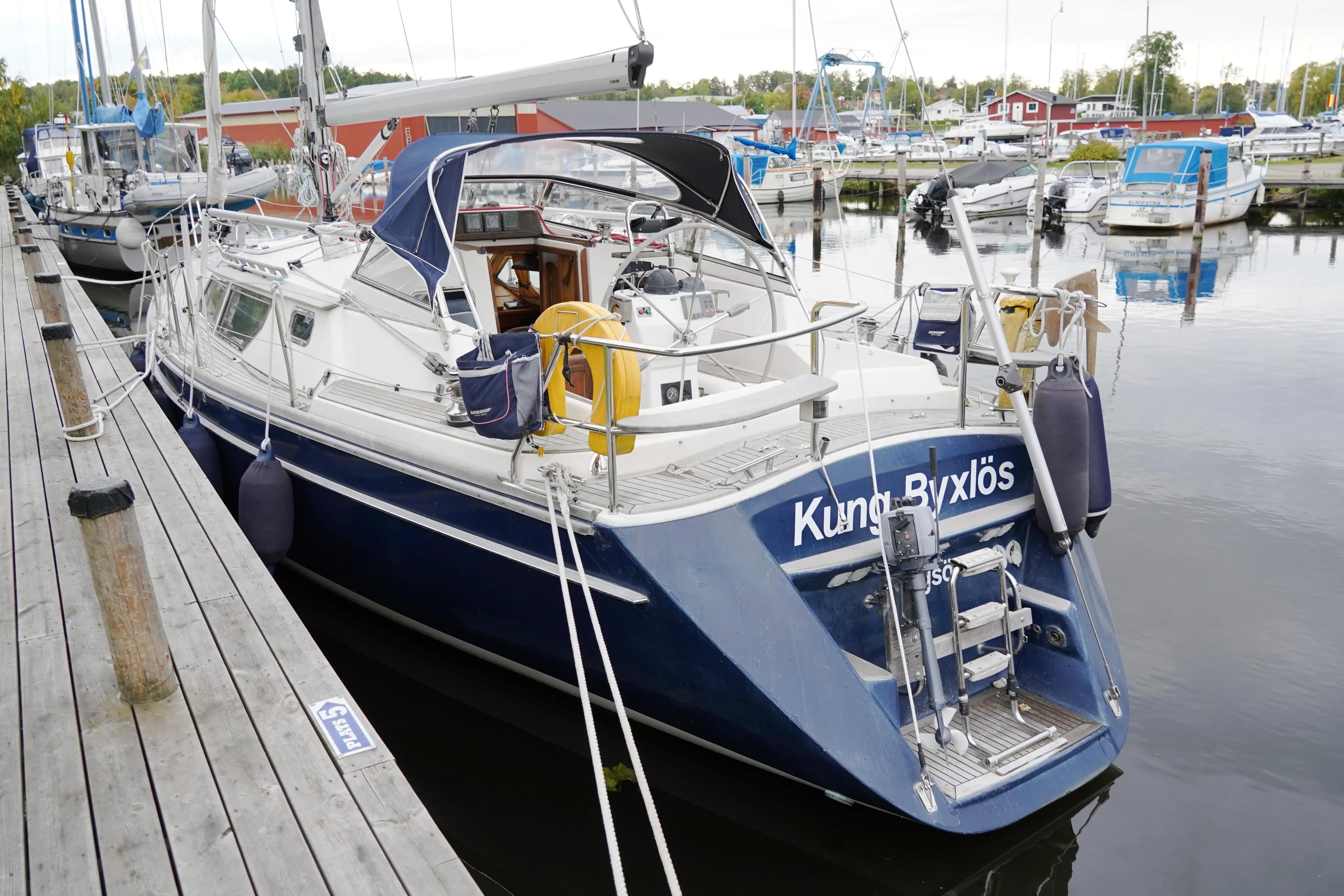 Sailboat docked at marina, CR 400 DS, 2002 model, with blue hull and white deck.