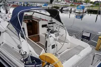Sailboat docked at marina, CR 400 DS model, 2002, with open cockpit and steering wheel.