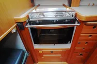 2002 CR 400 DS kitchen with stove and oven, wooden cabinetry, and countertop.
